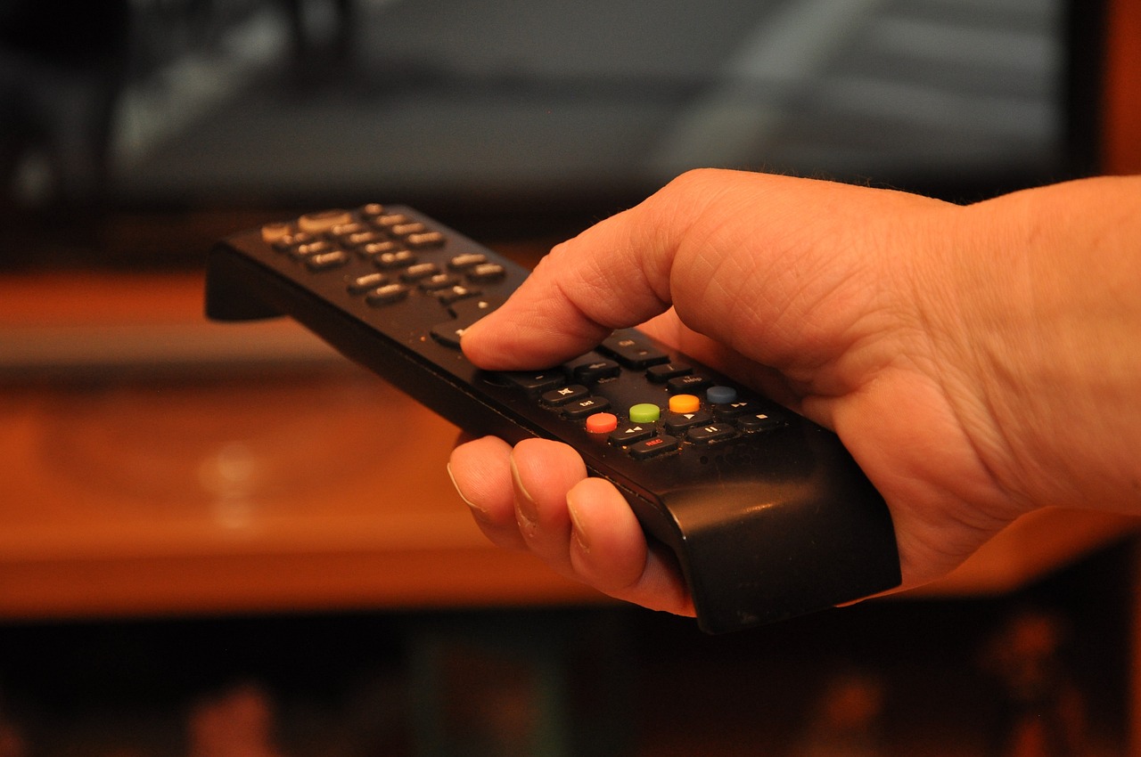 mulher assistindo TV controle remoto antena interna digital melhor antena digital 2026 — BuscaZip